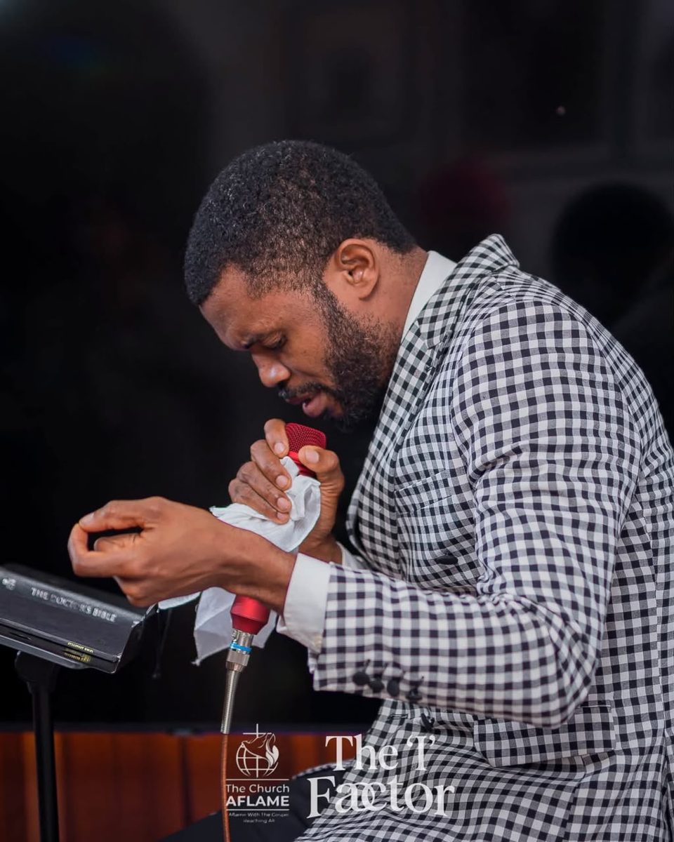 Minister praying with the microphone at the pulpit